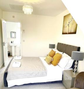 a bedroom with a large white bed with yellow pillows at Beautiful 3bedroom townhouse in a new estate in Great Yarmouth