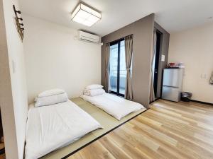 a room with two beds and a refrigerator at KYU KYU HOTEL in Tokyo