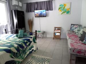a bedroom with two beds and a couch in it at Rava Lodge in Punaauia