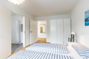 a bedroom with two beds and white cabinets at Penthouse Ferienwohnung in Bahlingen
