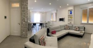 - un salon avec un canapé blanc et une table dans l'établissement Melitta apartment Giardini Naxos, à Giardini Naxos