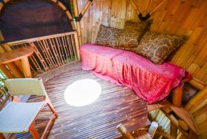 a room with a bed and chairs in a cabin at Le Bamboo Bali in Uluwatu