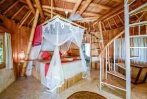 a bedroom with a canopy bed in a house at Le Bamboo Bali in Uluwatu