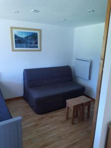 a living room with a blue couch and a table at The climber at Chamrousse #CU in Chamrousse