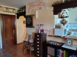 a kitchen with a counter with a microwave and a table at La Launa apartamento rural in Trevélez +34 photos