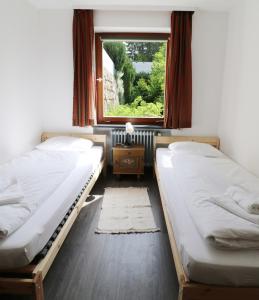 2 camas en una habitación con ventana en Haus Elisabeth - Fewo Freiburg, 1 Schlafzimmer, Feldberg nahe Skipiste, en Neuglashütten