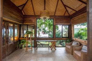 ein Wohnzimmer mit Holzwänden und großen Fenstern in der Unterkunft Stone Water Eco Resort in Bogmalo Beach