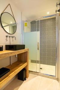 bagno con doccia e porta in vetro di Welcôm Apparts-chic et intimiste-100m du Port a La Teste-de-Buch