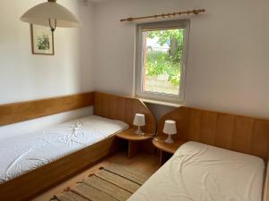 two beds in a room with a window at Apartamenty Przy Wydmach in Chłopy