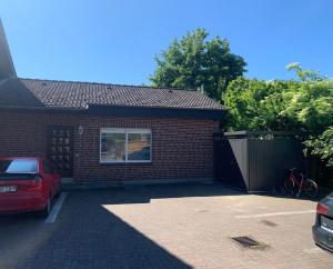 a brick house with a car parked in a driveway at Ferienbungalow in Pelzerhaken in Pelzerhaken