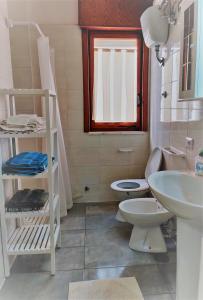 a small bathroom with a toilet and a sink at Mati in Poesia - San Foca in Melendugno +2 photos