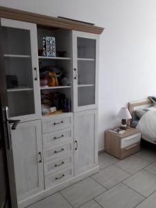 a large white cabinet in a bedroom with a bed at Sloneczny apartament w Giżycku in Giżycko