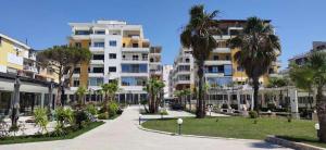 uma rua com palmeiras em frente aos edifícios em Wonderful Sea View Apartment Qerret em Golem