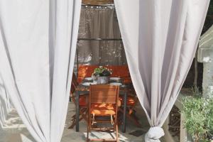 a table and chairs sitting on a patio with white curtains at Holiday house Nono in Sumartin
