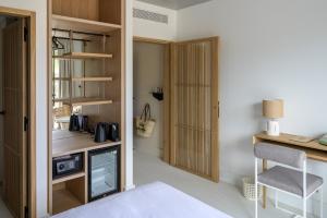 Cette chambre comprend un lit et un bureau avec une télévision. dans l'établissement Hôtel de La Plage, à Biarritz