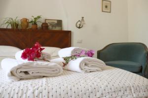 a bed with towels and flowers on top of it at Agriturismo Morani in Santa Severa