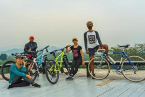 eine Gruppe von Menschen, die neben ihren Fahrrädern stehen in der Unterkunft SukSanti CoLiving and Vacation in Chiang Rai