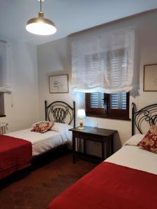 a bedroom with two beds and a table and a window at EL MOTIVO in Cercedilla