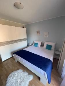 a bedroom with a large bed with blue and white sheets at Apartments Pecotić in Brna