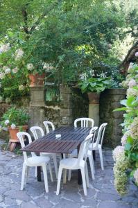 une table en bois entourée de chaises blanches dans l'établissement Tre Fiumi, à Ronta