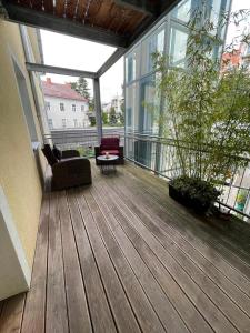 eine Terrasse mit einem Sofa und Stühlen auf dem Balkon in der Unterkunft Zentrum & Schöne Terasse in Graz