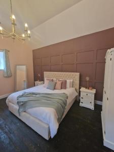 a bedroom with a large bed with a large headboard at Squirrel Cottage in Ballymena