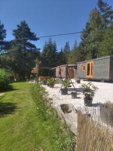 ein winziges Haus in einem Garten mit einem Zaun in der Unterkunft Maringotky Šumava in Sušice