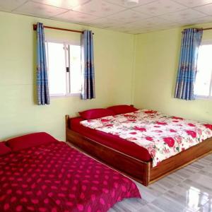 sypialnia z łóżkiem i czerwoną kołdrą w obiekcie แม่ป้อมโฮมสเตย์ ลานกางเต้นท์ริมโขง w mieście Ban Muang