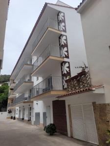 a large white building with balconies on it at Malva Hostel in L'Estartit