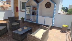 eine Terrasse mit Stühlen, einem Tisch und einem Haus in der Unterkunft Malva Hostel in L'Estartit