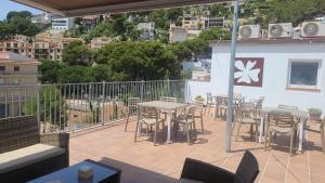 a patio with tables and chairs on a balcony at Malva Hostel Estartit in L'Estartit