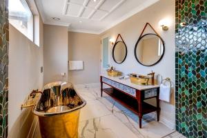 La salle de bains est pourvue d'un lavabo et d'un miroir. dans l'établissement Palm River Hotel, à Victoria Falls