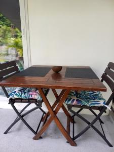 Rava Lodge في بوناويا: طاولة خشبية جلوس كرسيين بجانبها