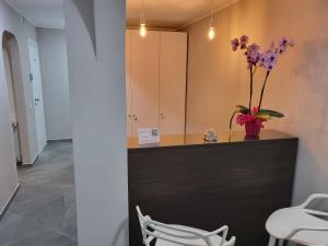 Cette chambre dispose d'un comptoir avec un vase aux fleurs violettes. dans l'établissement Casa dello stretto, à Messina
