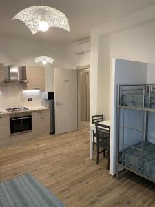 uma cozinha e sala de jantar com uma mesa e uma cozinha e um quarto com em Antica Dogana Apartments em Terracina