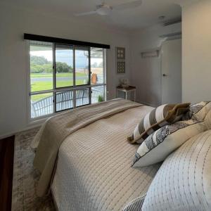 sypialnia z dużym łóżkiem i dużym oknem w obiekcie The Cove Cottage w mieście Pemberton