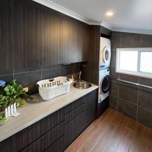 a kitchen with a sink and a washing machine at The Cove Cottage in Pemberton