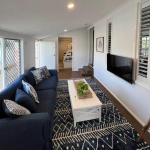 a living room with a blue couch and a table at The Cove Cottage in Pemberton +39 photos