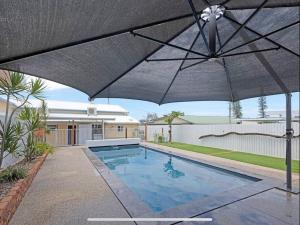 an umbrella over a swimming pool in a yard at The Cove Cottage in Pemberton