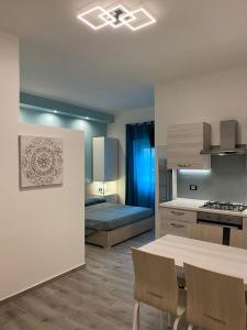 kuchnia ze stołem i łóżko w pokoju w obiekcie Antica Dogana Apartments w mieście Terracina