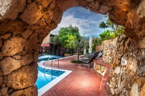 a view of a swimming pool through a stone wall at Kallisti Hotel in Potos