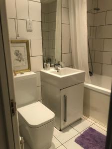ロンドンにあるRoom and private bathroom in the Whitehouseのトイレ、洗面台、浴槽を備えたバスルーム