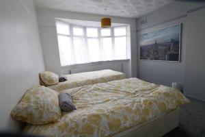1 Schlafzimmer mit 2 Betten und einem Fenster in der Unterkunft A stylish four bedroom house in wollaton in Nottingham