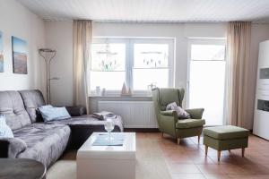 sala de estar con sofá y 2 sillas en Haus am Teich, en Hooksiel