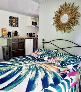 um quarto com uma cama com um edredão colorido em Rava Lodge em Punaauia