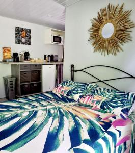 a bedroom with a bed with a colorful comforter at Rava Lodge in Punaauia