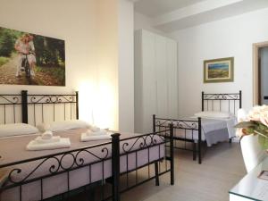 una camera con tre letti e un dipinto sul muro di Dimora Santa Barbara a Ferrara