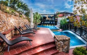 a patio with chairs next to a swimming pool at Kallisti Hotel in Potos