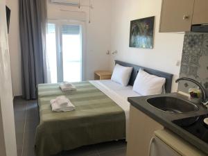 een hotelkamer met een bed en een wastafel bij Ammos Hotel in Agia Triada