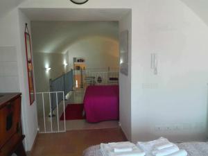 a room with a purple bed and a staircase at Appartamento Libeccio in Otranto